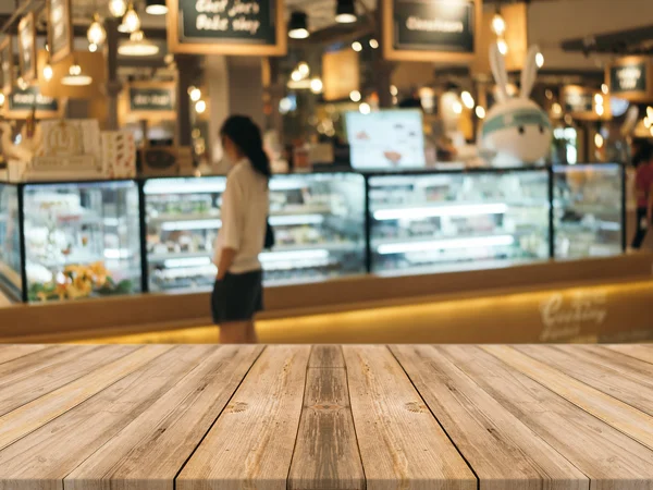 Tablero de madera mesa vacía en frente de fondo borroso. Perspectiva de madera marrón sobre desenfoque en la cafetería - se puede utilizar para la exhibición o montaje de sus productos.Prepárese para la exhibición del producto. — Foto de Stock