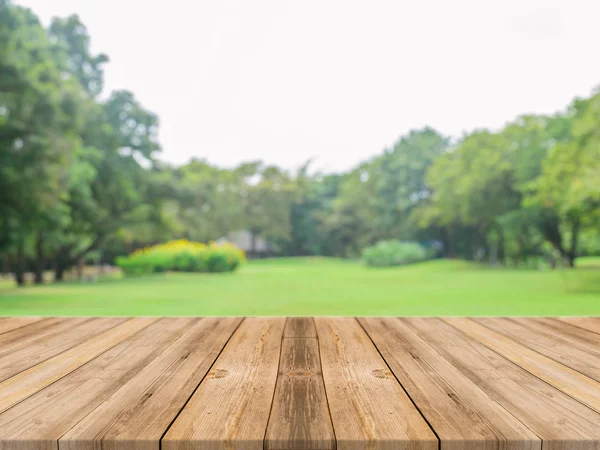 Tablero de madera mesa vacía en frente de fondo borroso. Perspectiva de madera gris sobre los árboles borrosos en el bosque - se puede utilizar para mostrar o montar sus productos. temporada de primavera. vintage imagen filtrada . — Foto de Stock