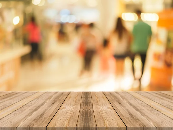 Tavola di legno tavolo vuoto di fronte alla gente shopping a sfondo fiera mercato. Mercato prospettiva legno e sfocatura - può essere utilizzato per visualizzare o montare i vostri prodotti - immagini effetto vintage . — Foto Stock