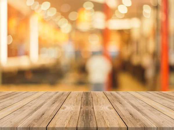 Tablero de madera mesa vacía en frente de fondo borroso. Perspectiva de madera marrón sobre desenfoque en la cafetería - se puede utilizar para la exhibición o montaje de sus productos.Prepárese para la exhibición del producto. — Foto de Stock