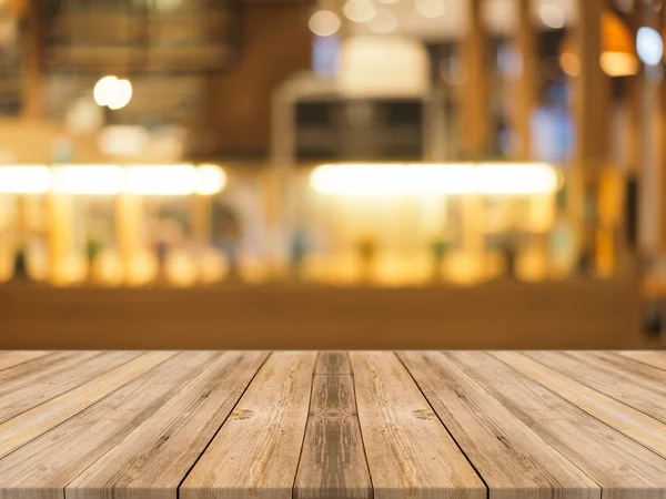 Tablero de madera mesa vacía en frente de fondo borroso. Perspectiva de madera marrón sobre desenfoque en la cafetería - se puede utilizar para la exhibición o montaje de sus productos.Prepárese para la exhibición del producto. — Foto de Stock