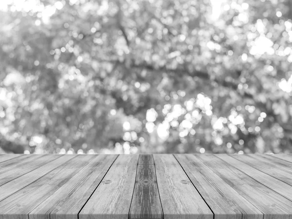 Holzbrett leerer Tisch vor verschwommenem Hintergrund. Perspektive graues Holz über unscharfe Bäume im Wald - kann für die Anzeige oder Montage Ihrer Produkte verwendet werden. Baumsilhouette. Vintage gefiltertes Bild. — Stockfoto
