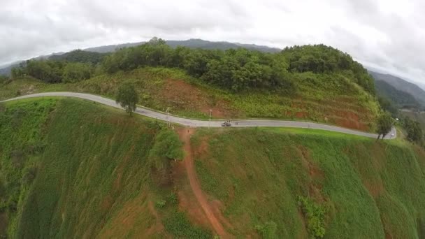 Vista aérea - Coche en un camino sinuoso en las colinas. Tailandia . — Vídeos de Stock