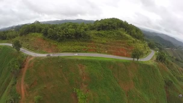 Vista aérea - Coche en un camino sinuoso en las colinas. Tailandia . — Vídeo de stock