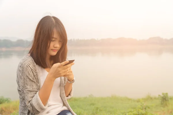 Closeup portrait upset sad skeptical unhappy serious woman talking texting on phone displeased with conversation isolated park outdoors background. Negative human emotion face expression feeling