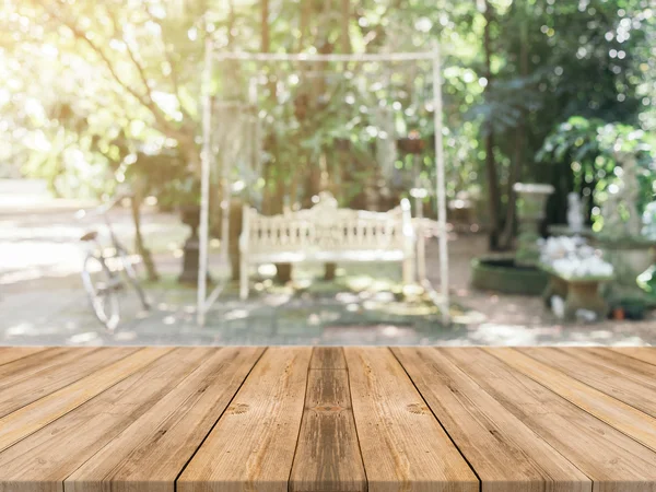 Tablero de madera mesa vacía en frente de fondo borroso. Perspectiva de madera marrón sobre los árboles borrosos en el bosque - se puede utilizar la maqueta para mostrar o montar sus productos. temporada de primavera. filtrado vintage . — Foto de Stock