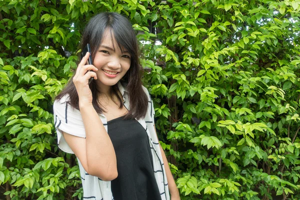 Schöne junge asiatische Frau, die am Telefon spricht — Stockfoto