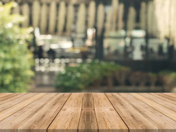 Tablero de madera mesa vacía en frente de fondo borroso. Perspectiva de madera marrón sobre desenfoque en la cafetería - se puede utilizar para la exhibición o montaje de sus productos.Prepárese para la exhibición del producto. — Foto de Stock