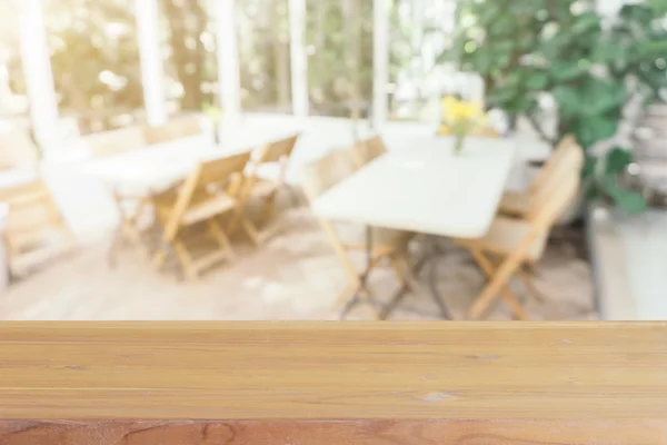 Tablero de madera mesa vacía en frente de fondo borroso. Perspectiva de madera marrón sobre desenfoque en la cafetería - se puede utilizar para la exhibición o montaje de sus productos.Prepárese para la exhibición del producto. — Foto de Stock
