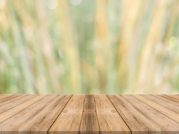 Tablero de madera mesa vacía en frente de fondo borroso. Perspectiva de madera marrón sobre los árboles borrosos en el bosque - se puede utilizar la maqueta para mostrar o montar sus productos. temporada de primavera. filtrado vintage . —  Fotos de Stock