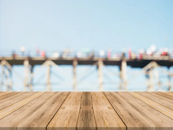 Holzbrett leerer Tisch vor verschwommenem Hintergrund. Perspektive braunes Holz über verschwommene Holzbrücke - kann als Attrappe zur Anzeige oder Montage Ihrer Produkte verwendet werden. Frühlingszeit. Jahrgang gefiltert. — Stockfoto