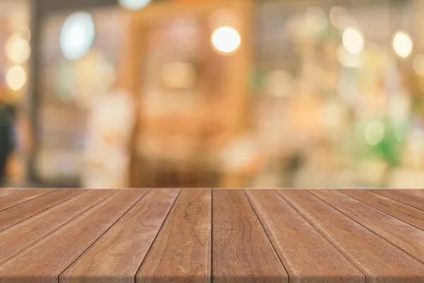 Дерев'яна дошка порожній стіл перед розмитим тлом. Перспективна коричнева деревина над розмиттям у кав'ярні може бути використана для демонстрації або моніторингу вашої продукції. . — стокове фото