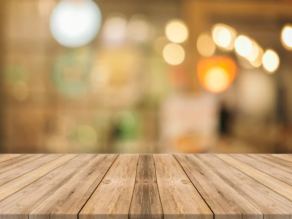 背景がぼやけて目の前の木製のボードの空のテーブル。コーヒーショップでぼかしの上にパースペクティブ茶色の木-製品を表示またはモンタージュするために使用できます。. — ストック写真