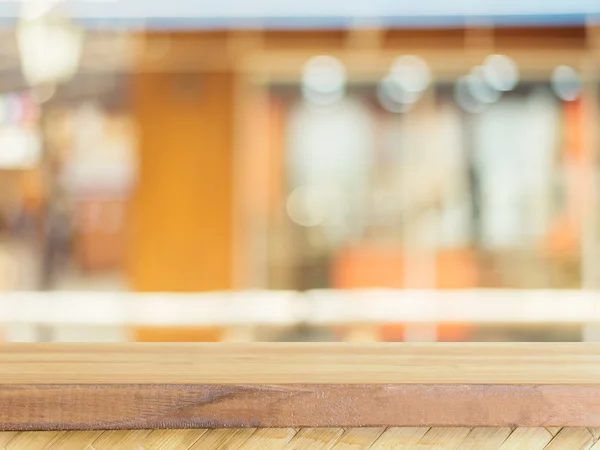 Table vide en bois devant un fond flou. Perspective bois brun sur flou dans le café - peut être utilisé pour l'affichage ou le montage de vos produits.. — Photo