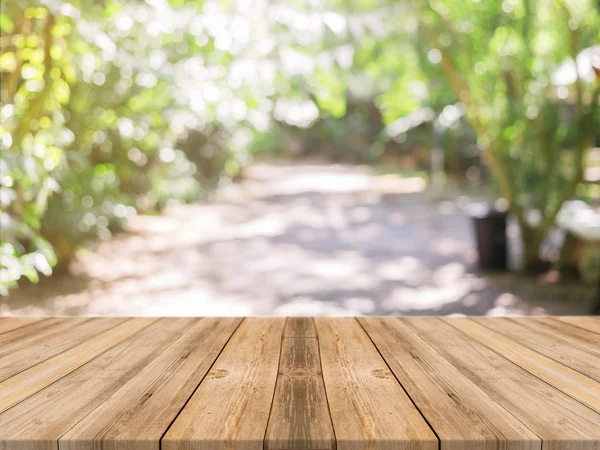 Holzbrett leerer Tisch vor verschwommenem Hintergrund. Perspective braunes Holz über Unschärfe im Café - kann für die Anzeige oder Montage Ihrer Produkte verwendet werden.Mock up für die Anzeige des Produkts. — Stockfoto