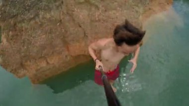 Adam okyanusa uçurumdan atlama.