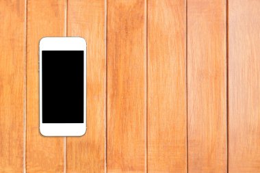Üstten Görünüm smartphone şablon boşaltmak ile ahşap masa üstünde siyah perde ile alay etmek.
