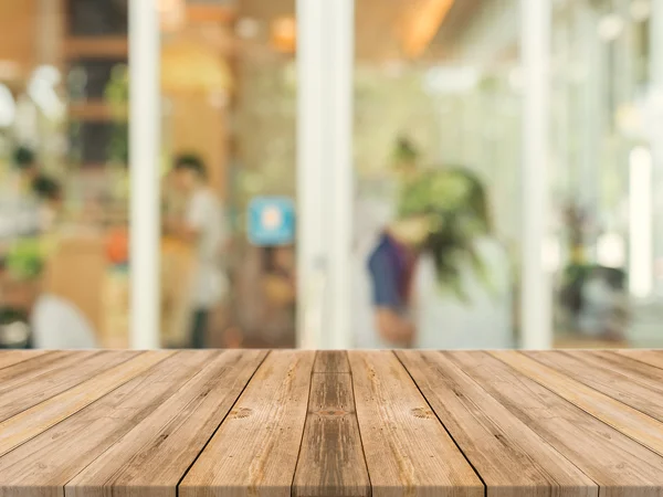 Tavola in legno tavolo vuoto di fronte a sfondo sfocato. Prospettiva legno marrone su sfocatura in caffetteria - può essere utilizzato per visualizzare o montare i vostri prodotti. finto per la visualizzazione del prodotto. — Foto Stock