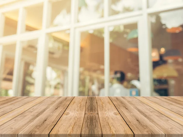 Tablero de madera mesa vacía en frente de fondo borroso. Perspectiva de madera marrón sobre desenfoque en la cafetería - se puede utilizar para la exhibición o montaje de sus productos.Prepárese para la exhibición del producto. — Foto de Stock