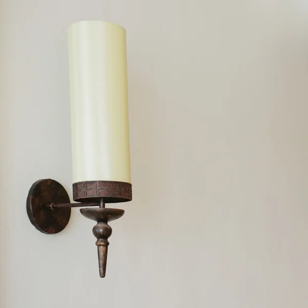 Una lámpara solitaria en una pared de textura pálida —  Fotos de Stock