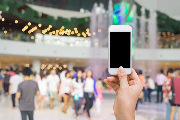 Smarttelefon med hvit skjerm på uskarpt i kjøpesenterbakgrunn, netthandel, smarttelefon – stockfoto