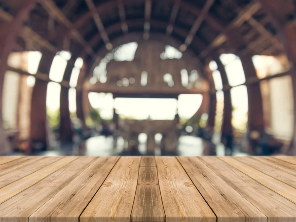 Tablero de madera mesa vacía en frente de fondo borroso. Perspectiva de madera marrón sobre desenfoque en la cafetería - se puede utilizar para la exhibición o montaje maqueta de sus productos. vintage imagen filtrada . — Foto de Stock