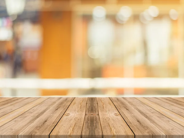 Tablero de madera mesa vacía en frente de fondo borroso. Perspectiva de madera marrón sobre desenfoque en la cafetería - se puede utilizar para la exhibición o montaje maqueta de sus productos. vintage imagen filtrada . — Foto de Stock