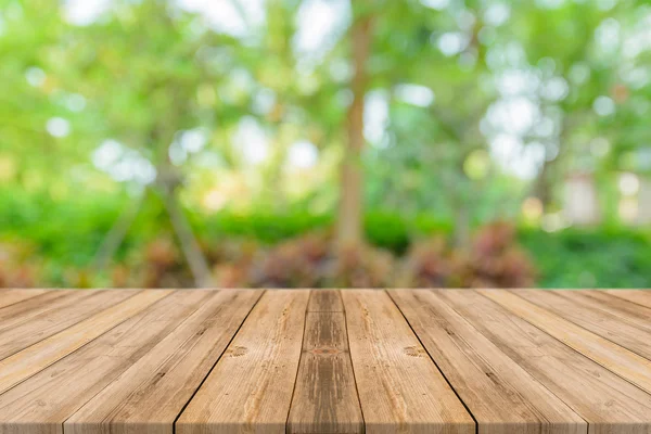 Tablero de madera mesa vacía en frente de fondo borroso. Perspectiva de madera marrón sobre los árboles borrosos en el bosque - se puede utilizar la maqueta para mostrar o montar sus productos. temporada de primavera. filtrado vintage . — Foto de Stock
