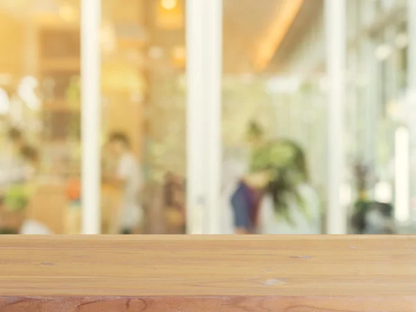 Tablero de madera mesa vacía en frente de fondo borroso. Perspectiva de madera marrón sobre desenfoque en la cafetería - se puede utilizar para la exhibición o montaje de sus productos.Prepárese para la exhibición del producto. — Foto de Stock