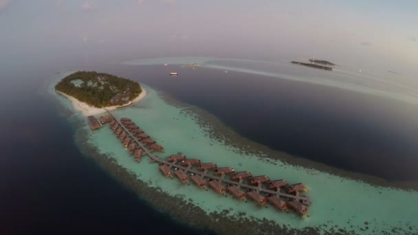 Luftaufnahme von Sonnenuntergang über dem Meer und luxuriösen Überwasser-Villen auf tropischen Insel Resort, Malediven. — Stockvideo