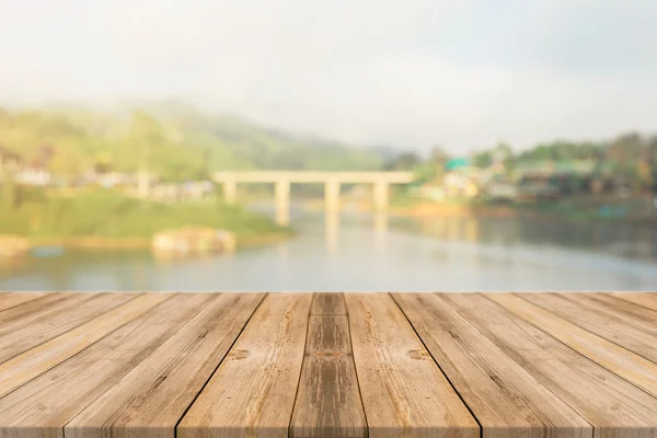 Holzbrett leerer Tisch vor verschwommenem Hintergrund. Perspektive braunes Holz über verschwommene Holzbrücke - kann als Attrappe zur Anzeige oder Montage Ihrer Produkte verwendet werden. Frühlingszeit. Jahrgang gefiltert. — Stockfoto