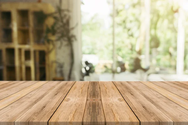 Holzbrett leerer Tisch vor verschwommenem Hintergrund. Perspective braunes Holz über Unschärfe im Café - kann für die Anzeige oder Montage Ihrer Produkte verwendet werden.Mock up für die Anzeige des Produkts. — Stockfoto