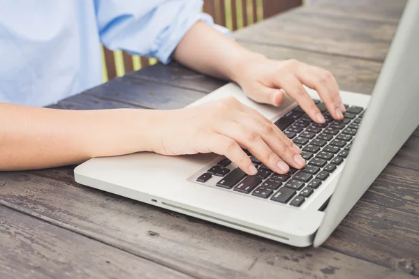 Jovem mulher usando computador portátil. Feminino trabalhando em laptop em um café ao ar livre . — Fotografia de Stock