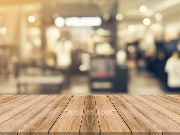 Holzbrett leeren Tisch verschwimmt Hintergrund. Perspektive braunes Holz über Unschärfe im Kaufhaus - kann zur Anzeige oder Montage Ihrer Produkte verwendet werden.. — Stockfoto