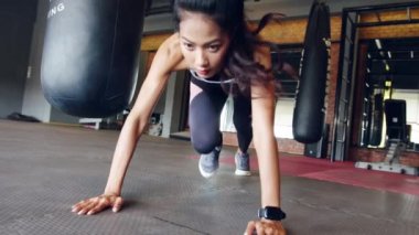 Jimnastik sınıfında dağcı yağ yakma egzersizi yaparken mutlu Asya 'lı genç bayan egzersizleri. Altılı paketli sporcu, sportif kadın aktivitesi, fonksiyonel eğitim, sağlıklı yaşam tarzı konsepti.