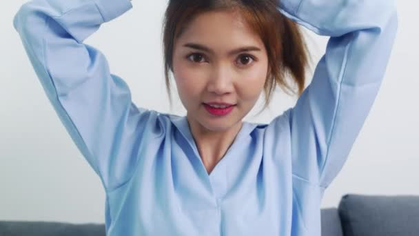 年轻的亚洲女人在前视镜下做长发 快乐的女人做马尾辫来改善自己在卧室里的工作状态 家庭生活方式的妇女概念 — 图库视频影像