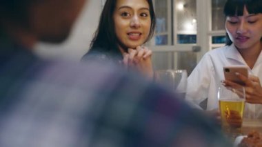Bir grup mutlu Asya 'lı genç turist cep telefonu kullanıyor, alkollü bira içiyor ve Khao San Road' daki gece kulübünde eğleniyorlar. Gezgin gezgin Asya insanları Bangkok, Tayland 'a seyahat ediyor..