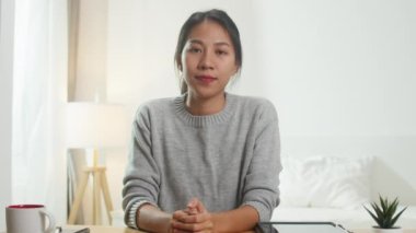 Bilgisayarı kullanan genç Asyalı iş kadını, yatak odasında çalışırken iş arkadaşlarıyla görüntülü görüşme planları hakkında konuşuyor. Kişisel izolasyon, sosyal uzaklık, korona virüsü için karantina.