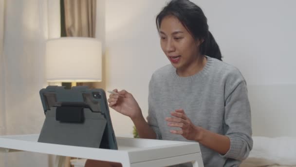 亚洲女商人一边用平板电脑和同事们谈论视频通话的计划 一边在卧室的床上聪明地工作 自我隔离 社会疏离 冕病毒预防检疫 — 图库视频影像