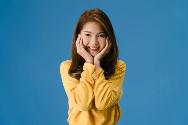 肯定的な表情で若いアジアの女性は 笑顔を広く カジュアルな布に身を包んだと青の背景に隔離されたカメラを見て 幸せな愛らしい幸せな女性は成功を喜びます 表情コンセプト — ストック写真