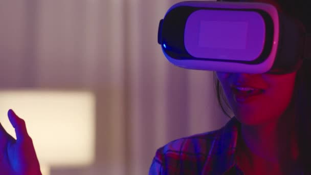 亚洲女人穿着Vr游戏耳机 有着有趣的体验 可穿戴虚拟增强型现实数码创新科技快乐时刻霓虹灯之夜庆祝活动在客厅举行 — 图库视频影像