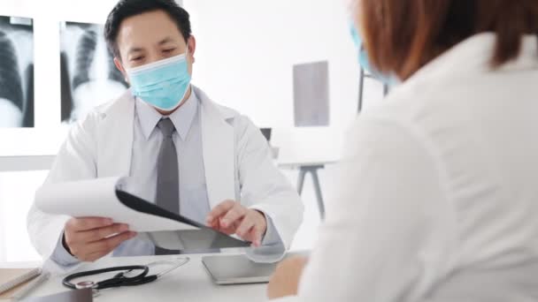 Dokter Pria Asia Yang Serius Mengenakan Topeng Pelindung Menggunakan Clipboard — Stok Video