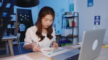 Serbest çalışan Asyalı kadınlar yeni normal ofis bilgisayarlarında çok çalışıyorlar. Geceleri ev aşırı yükleme, uzaktan çalışma, kişisel izolasyon, sosyal uzaklık, korona virüsünün önlenmesi için karantina.