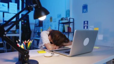 Serbest çalışan Asya 'lı bayan, yeni ev ofisinde uyumaktan yoruldu. Geceleri ev aşırı yükleme, uzaktan izolasyon, sosyal uzaklık, korona virüsünün önlenmesi için karantina.