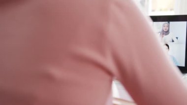 Dizüstü bilgisayar kullanan genç Asyalı iş kadını, evden oturma odasındaki çalışma saatlerinde yapılan telefon görüşmesinin planlarını meslektaşına anlatıyor. Kişisel izolasyon, sosyal uzaklık, korona virüsünün önlenmesi için karantina.