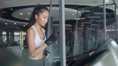 Spor giyim egzersizinde genç atlet Asyalı bayan fitness sınıfında koşu bandında yağ yakma egzersizi yapıyor. Korona virüsünün önlenmesi için kardiyo eğitimi, kişisel izolasyon, sosyal mesafeler, karantina.