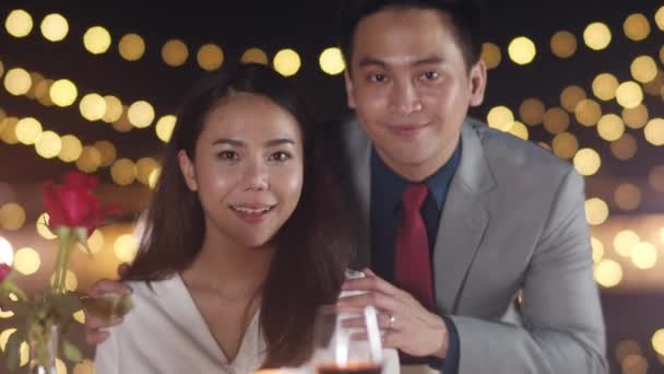 一对年轻的亚洲夫妇带着甜蜜的时刻庆祝结婚周年 在城市夜晚的楼顶餐厅里 在浪漫的晚餐上拍照 以纪念他们的幸福时刻 恋爱关系 结婚观念 — 图库视频影像