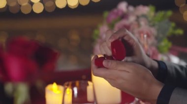 Genç Asyalı kız arkadaşlara romantik bir akşam yemeğinde evlenme teklif et. Şehir gecesinde çatıdaki restoranda şarap iç ve yıldönümünü kutla. Aşk ilişkisi, evlilik kavramı kutlaması.