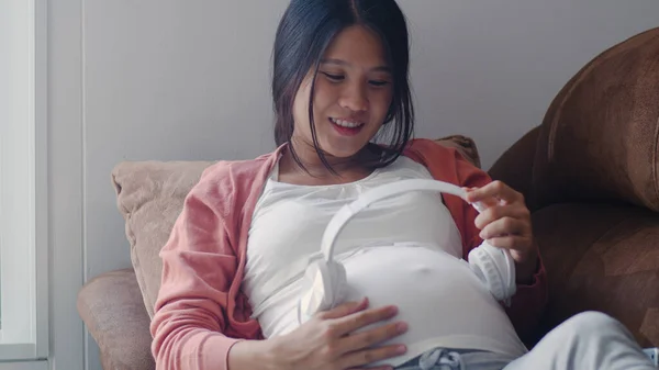 Młoda Kobieta Ciąży Azjatyckiej Pomocą Telefonu Słuchawki Odtwarzać Muzykę Dla — Zdjęcie stockowe