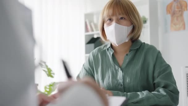 Young Asia Lady Doctor Wear Protective Mask Using Clipboard Providing — Video